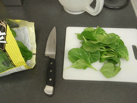 Spinaci baby già puliti e lavati sul tagliere