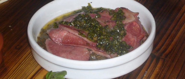 Lingua salmistrata in salsa verde su letto di lenticchie