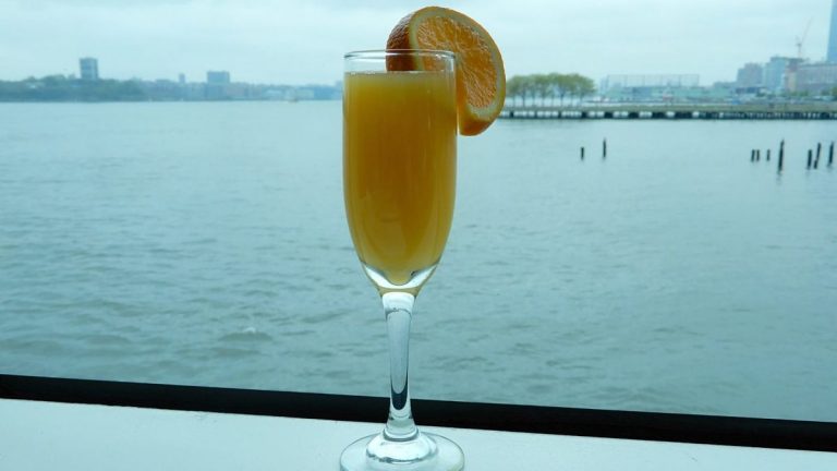 Cocktail Mimosa nel bicchiere con fetta di arancia per guarnizione