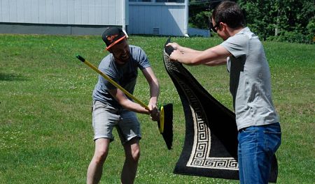 Padre e figlio puliscono un tappeto