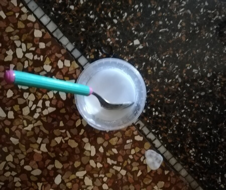 Pastetta smacchiante di bicarbonato e acqua su pavimento in graniglia di marmo