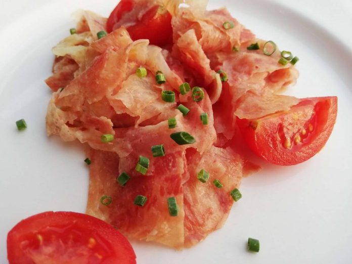 Insalata di testina di vitello tagliata sottilmente Testina di vitello in insalata con pomodori ed erba cipollina