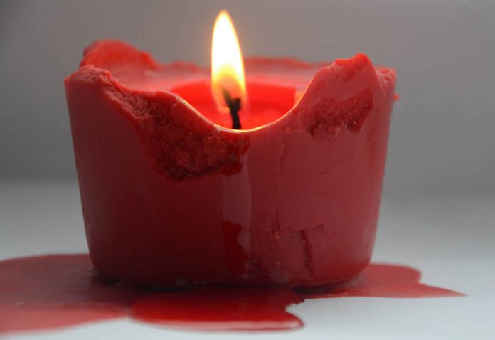 Cera di candela colorata caduta sul pavimento Cera di candela rossa colata su pavimento bianco