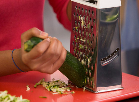 Donna grattugia una zucchina