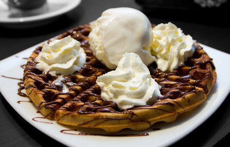 Waffle di zucca decorati con gelato, panna e cioccolato fuso