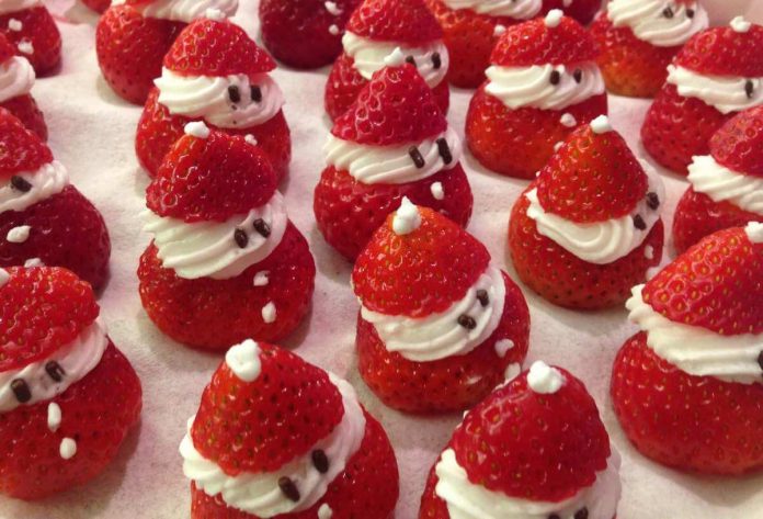 Aspetto festoso delle fragole con panna montata di Babbo Natale