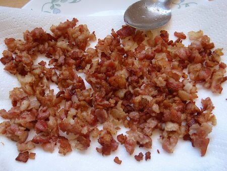 Dadini piccoli di pancetta rosolata su carta assorbente