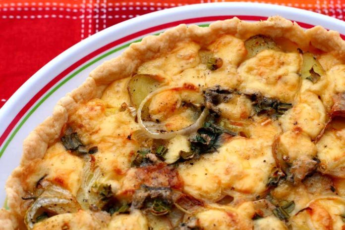 Quiche di patate, cipolle e gorgonzola intera nel piatto di portata
