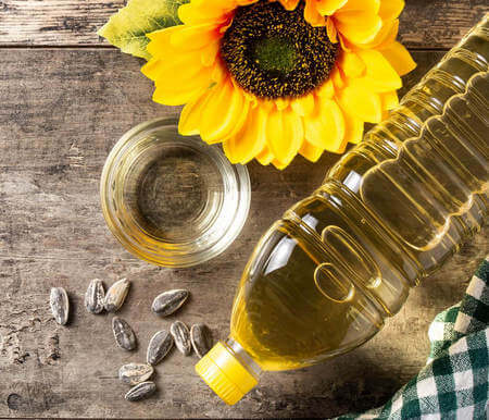 Bottiglia e ciotola contenenti olio di semi di girasole
