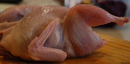 Anatra intera lavata su tagliere di legno