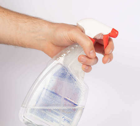 Spruzzino contenente prodotto adatto alla pulizia dei vetri della doccia in mano maschile