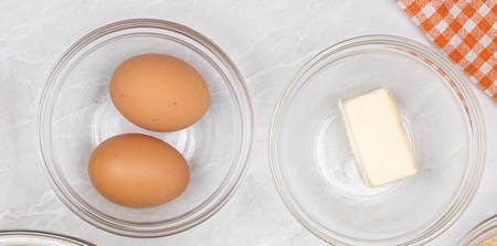 Uova intere e burro in 2 ciotole diverse
