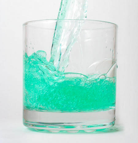 Collutorio versato in bicchiere di vetro