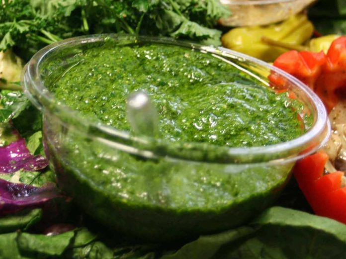Gustoso e salutare pesto di rarassaco fatto in casa dentro a ciotola di vetro Ciotola di vetro contenente pesto di tarassaco fatto in casa