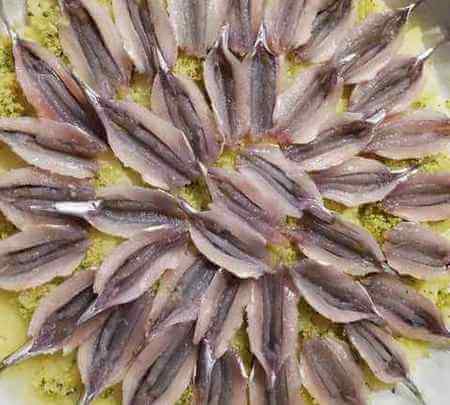 Acciughe crude su letto di patate scottate nella teglia