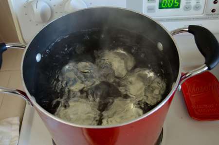 Vasetti contenenti conserva mesi a pastorizzare in acqua bollente