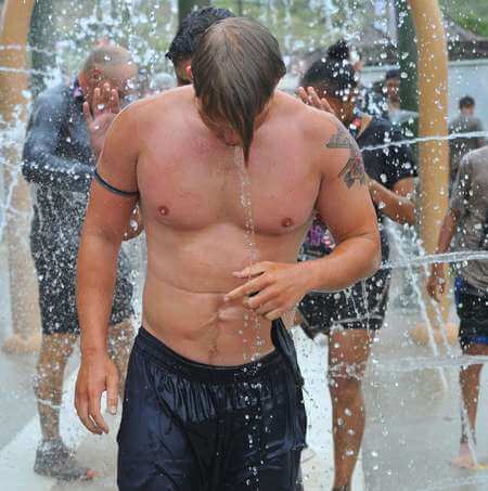 Ragazzo si sciacqua i capelli sotto la doccia