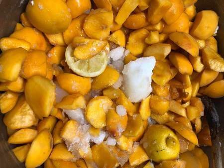 Pesche a pezzi, zucchero e limoni in macerazione