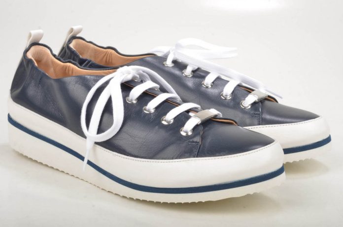 Lacci bianchi puliti e candidi su sneakers da donna