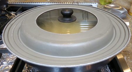 Cibo in cottura nella padella coperta da coperchio di alluminio e vetro trasparente