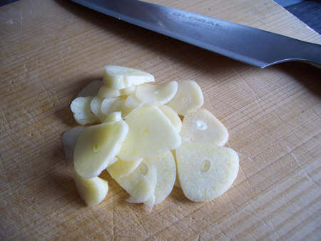 Aglio tagliato a fette sottili con un coltello affilato