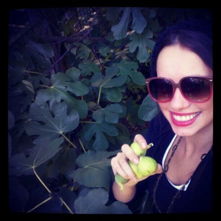 Donna con in mano fichi non ancora maturi appena raccolti