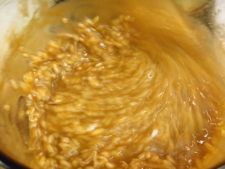 Risotto in movimento durante la mantecatura all'onda