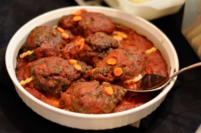 Pirofila contenente polpette a forma di topo al sugo golose e perfette per Halloween Polpette a forma di topo di Halloween condite con sugo al pomodoro in pirofila di ceramica bianca