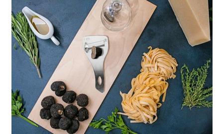 Tartufi neri interi accanto ad apposito tagliatartufi