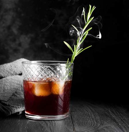 Mirto con cubetti di ghiaccio e decoro di rosmarino nel bicchiere