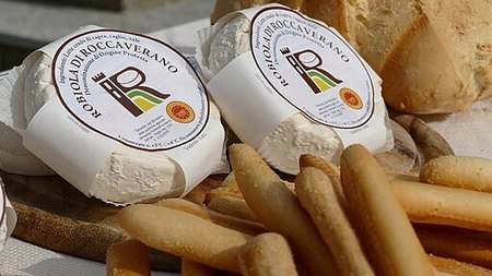 2 forme intere di robiola di Roccaverano accanto a pane e grissini