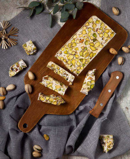 Torrone tagliato su tagliere con coltello vicino