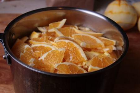 Arance sbucciare e tagliate dentro a pentola di acciaio