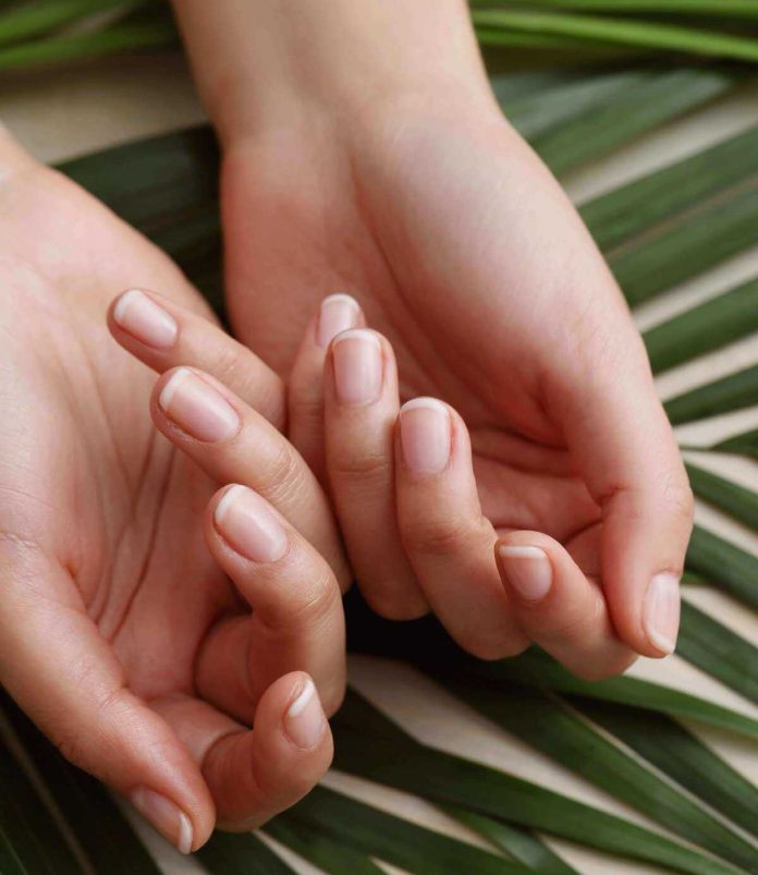 Donna con unghie rafforzate con l'adeguata alimentazione