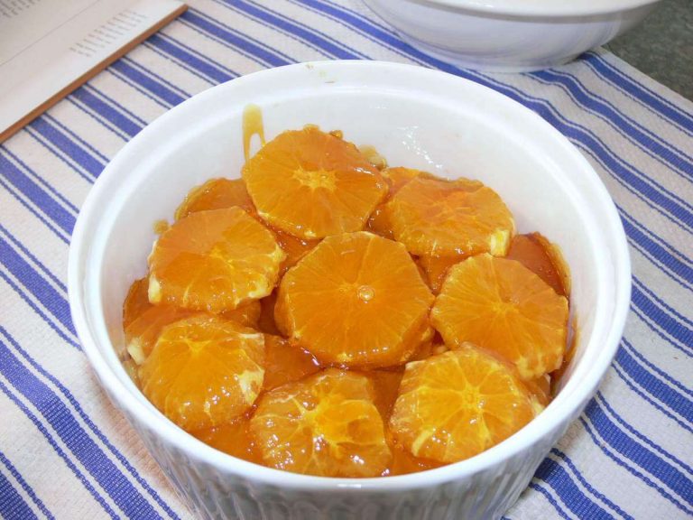 Ciotola bianca contenente arance caramellate al brandy cotte in padella