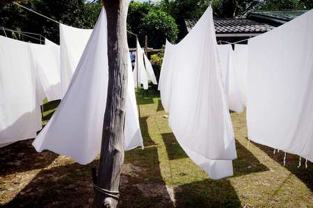 Lenzuola bianche stese su corde in pieno sole