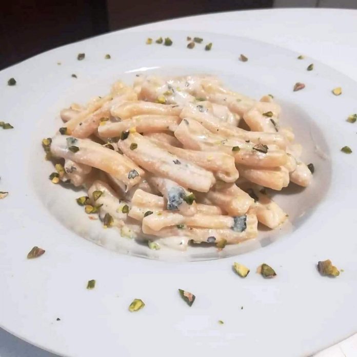 Piatto contenente pasta con ricotta e pistacchi al profumo di limone