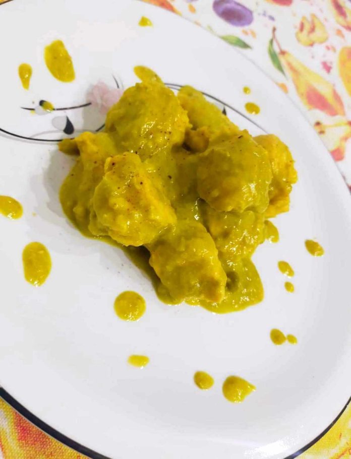 Bocconcini di pollo con zafferano e crema di piselli su piatto bianco