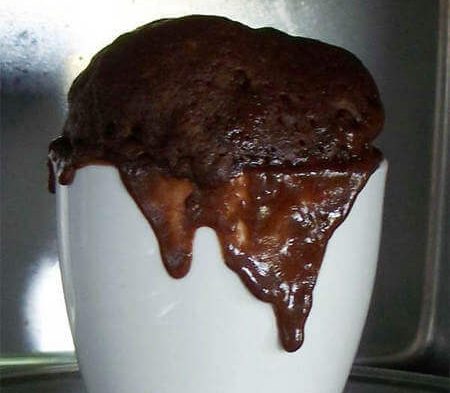 Mug cake gonfiata e fuoriuscita dalla tazza durante la cottura cottura