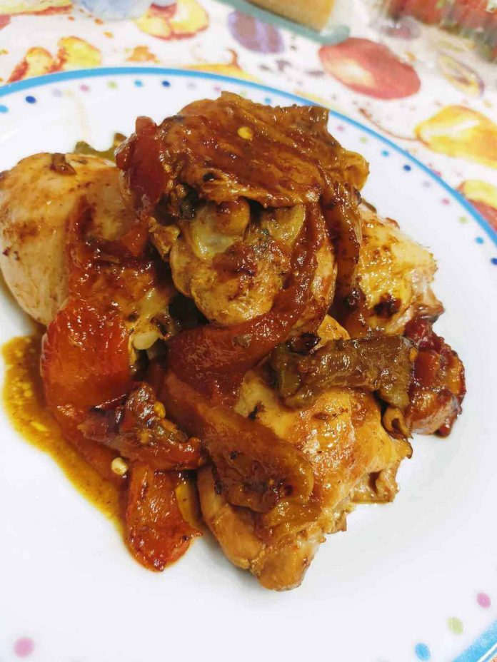 Succulento pollo con peperoni arrostiti porzionato in piatto individuale Pollo con peperoni arrostiti alla calabrese nel piatto