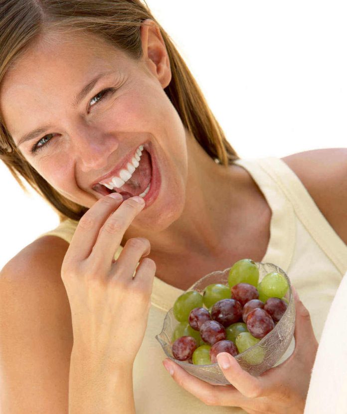 Donna mangia uva da cui ha eliminato i pesticidi
