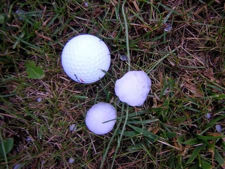 Grossi chicchi di grandine accanto a pallina da golf