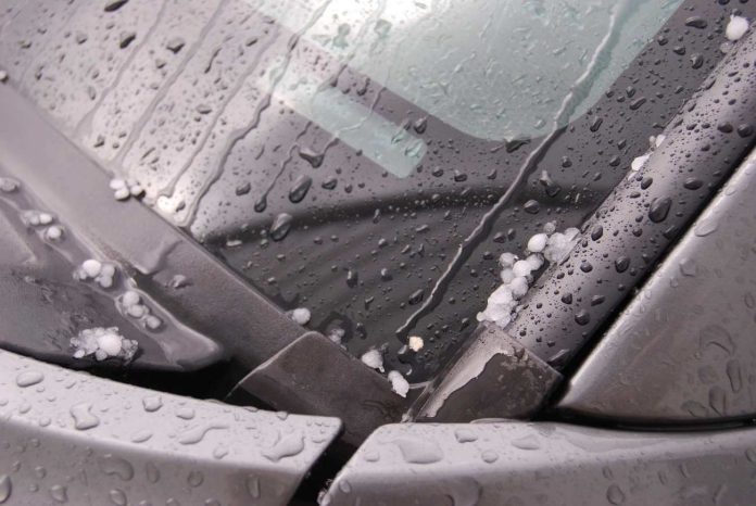 Chicci di grandine precipitati sul parabrezza di un'automobile Grandine sul parabrezza di un'auto