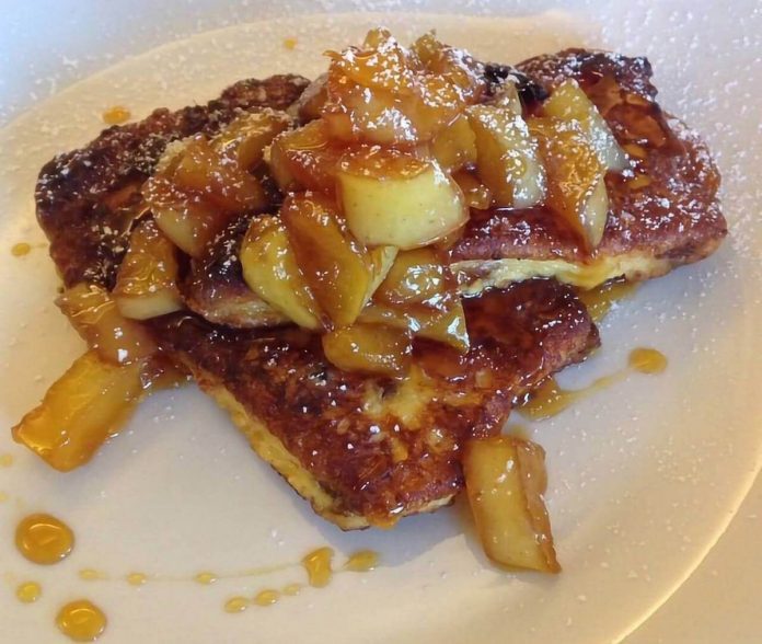 Invitante e prelibato french toast di panettone servito con mele caramellate French toast di panettone con mele caramellate sul piatto individuale