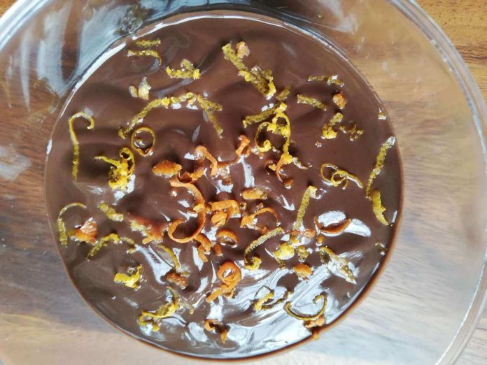 Deliziosa crema al cioccolato e arance fatta senza uova e senza farina Crema al cioccolato e arance senza uova vegana spolverata con scorze di agrumi