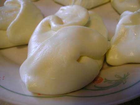 Burrate artigianali lucide e del colore del latte fatte da poco