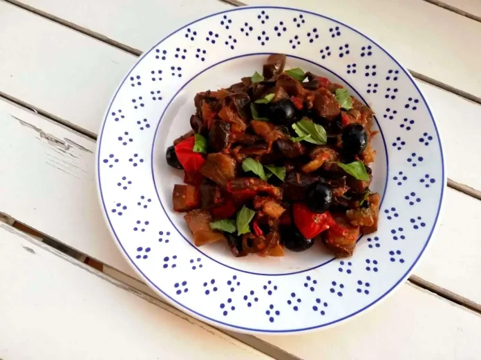 Melanzane alla mediterranea in padella servite in un piatto fondo