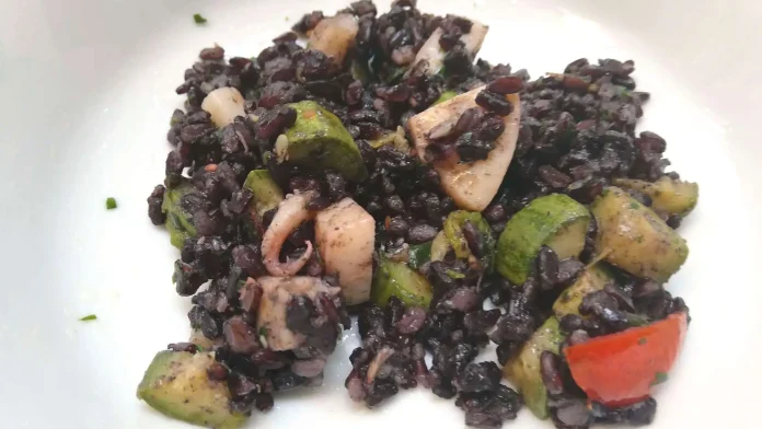Porzione di insalata light di riso venere, seppie e verdure di stagione nel piatto