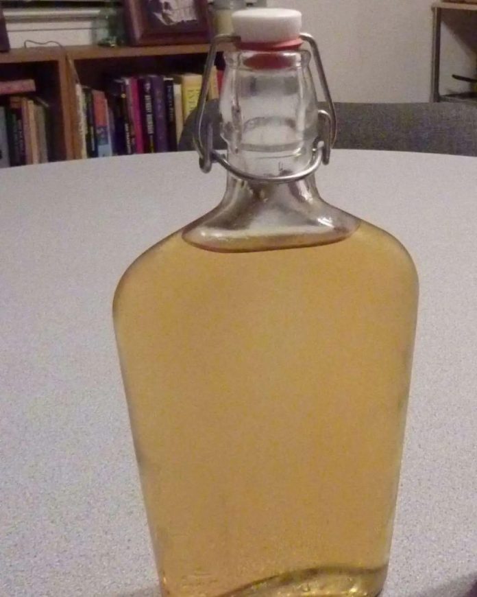 Bottiglie contenente delizioso e digestivo liquore di achillea Liquore di achillea fatto con la ricetta valtellinese e imbottigliato.