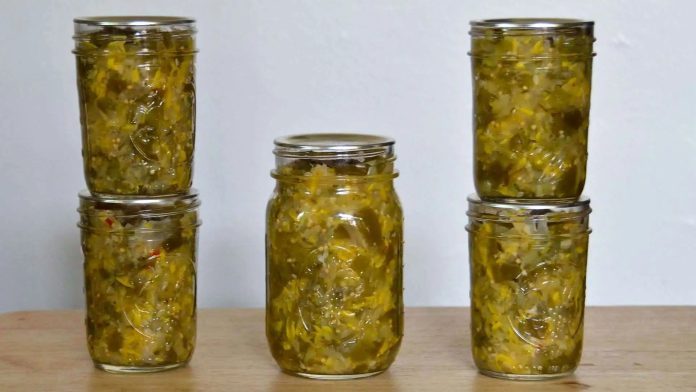 Relish di zucchine e peperoni agrodolce invasato in barattoli di vetro